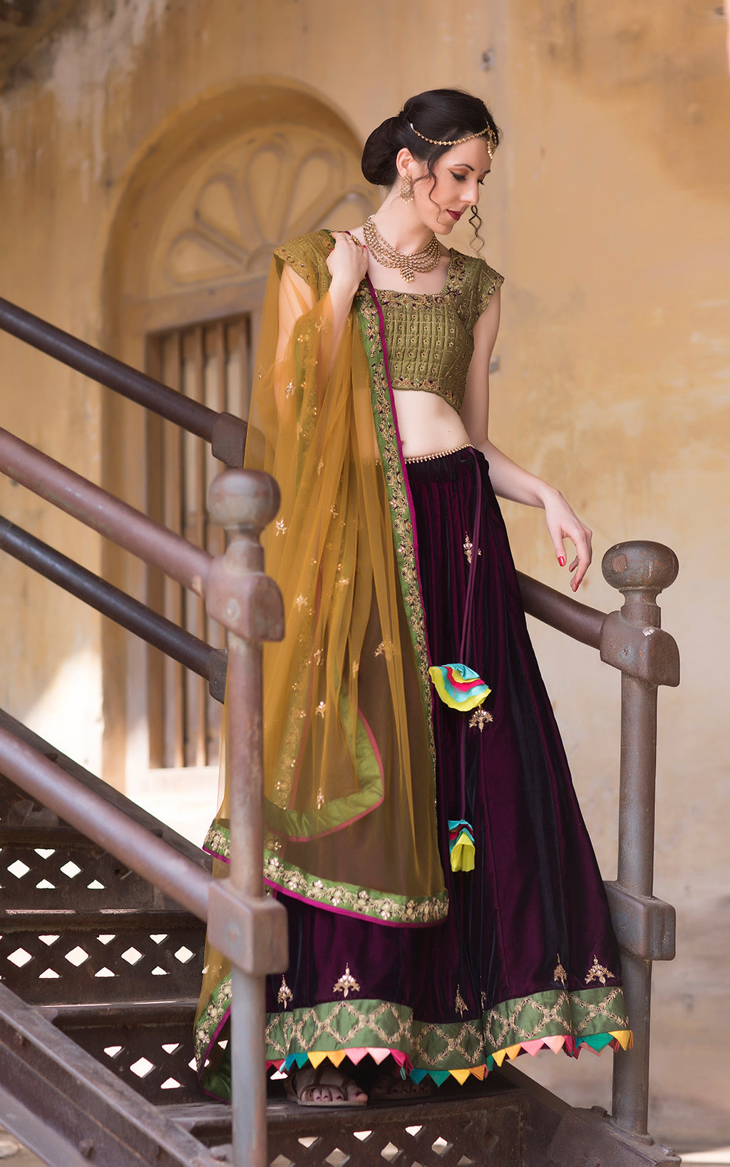 Wine velvet panelled lehenga with multicolor border detail ,with cap sleeve green blouse and mustard tulle dupatta