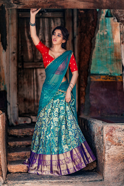 Sweetheart neck red brocade silk blouse with blue knife pleat kanchi silk skirt and blue tulle dupatta