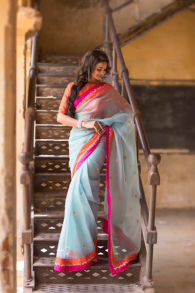 Boat neck raw silk orange blouse with blue organza saree