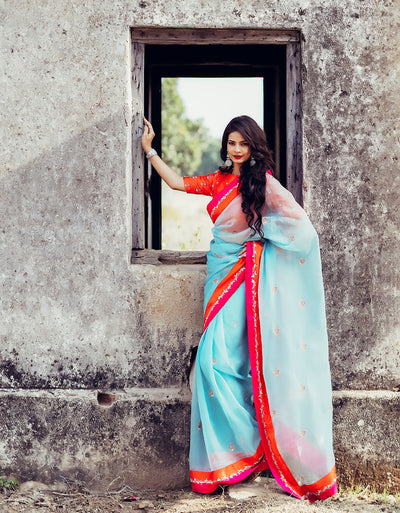 Boat neck raw silk orange blouse with blue organza saree